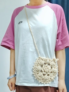 Handmade crochet flower crossbody bag with pearl accents shown on a model
