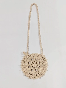 Detail of handmade crochet round crossbody bag with floral patterns and pearl beads