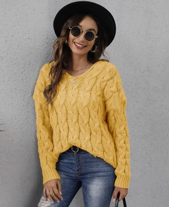 Detail shot of chunky cable knit pattern and V-neckline on yellow hooded sweater