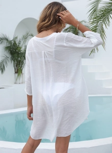 Gros plan du cache-maillot de plage blanc semi-transparent en tissu texturé au bord de l'eau