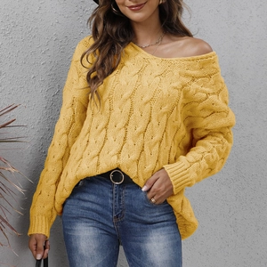 Close-up of ginger yellow cable knit texture on a loose V-neck hooded sweater