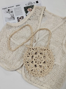 Detail of handmade crochet shoulder bag featuring floral patterns and pearl accents