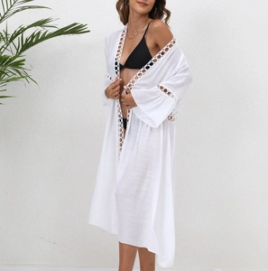 Close-up of bohemian white lace detailing on a beach cover-up with hollow ring patterns