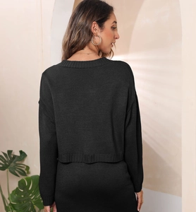 Back view of a casual loose knit black cardigan with textured weave and ribbed hem details