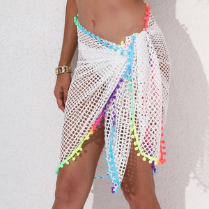 Détail de la jupe de plage en crochet blanc avec bordure à pompons colorés
