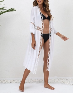 Detail of white lace patchwork on beach cover-up with delicate crochet hollow design