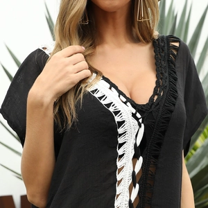 Close-up of deep V-neckline with black and white crochet trim on a beach dress
