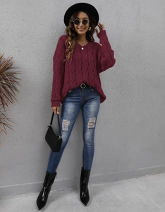 Close-up of wine red cable knit texture and elegant V-neck design on women's thick sweater
