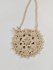Close-up of handmade crochet bag with floral patterns and delicate pearl embellishments