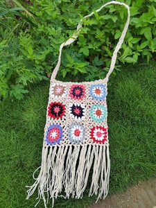 Detailed view of handmade bohemian crochet bag with colorful floral granny square patterns