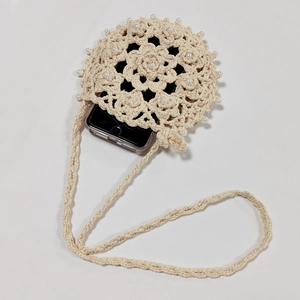 Detailed close-up of handmade crochet sunflower phone bag with white pearl accents
