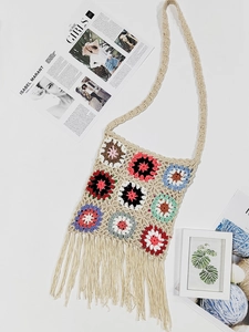 Detailed close-up of handmade bohemian crochet shoulder bag with colorful floral granny squares