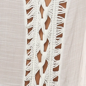 Close-up detail of white bohemian knit dress featuring intricate crochet diamond cut-outs