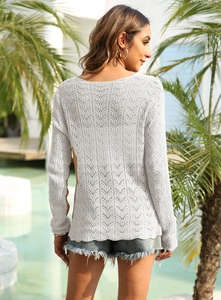 Détail du haut en maille crochet blanche avec motif ondulé ajouré et manches longues chic
