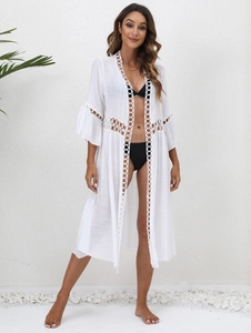 Detailed close-up of white crochet lace panels and breathable fabric on a beach cover-up