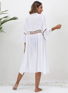 Detail of white beach cover-up featuring intricate circular lace crochet on back and sleeves
