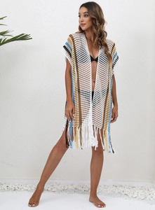 Detail of bohemian crochet beach cover-up featuring colorful stripes and fringe tassels