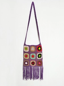 Detailed close-up of a handmade purple crochet crossbody bag with colorful granny squares and tassels