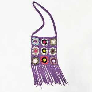 Detail of purple crochet granny square crossbody bag with handmade tassel trim and strap