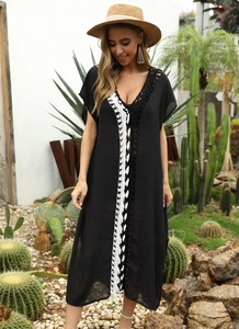 Detailed view of the bohemian white floral embroidery on a black V-neck beach dress