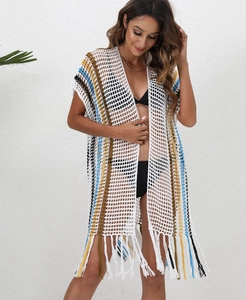 Detail of bohemian crochet beach cover-up featuring colorful striped mesh and long tassels