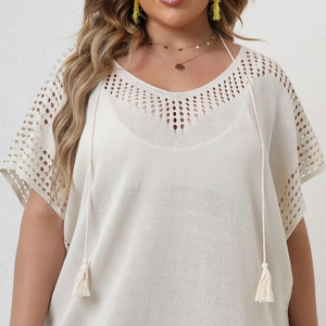 Détail de robe de plage au crochet avec col en V ajouré, cordon et glands