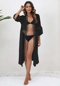 Detail of black beach cover-up with round hollow crochet lace and breathable light fabric