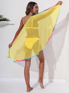 Détail de cache-maillot en maille jaune avec bordure de pompons colorés et vibrants