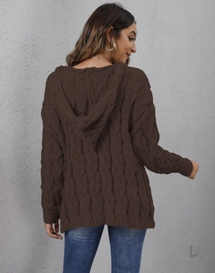Detail of dark brown cable-knit texture and large hood on women's oversized sweater