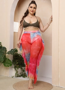 Detail of crochet halter top with shell fringe and colorful tie-dye ruffle beach pants