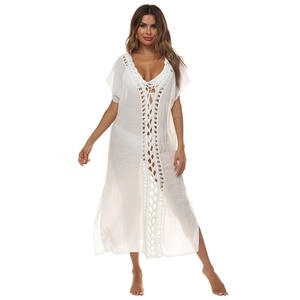 Detail of white V-neck beach cover-up featuring intricate hollow crochet lace and side slits