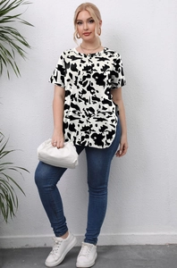 Detail view of the cow print pattern and side slit hem on this plus size t-shirt