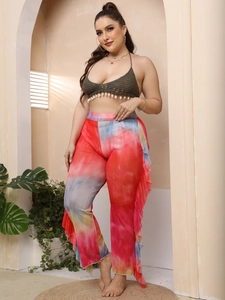 Detailed close-up of mesh see-through flared trousers with ruffle trim and tie-dye pattern