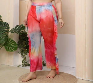 Detail of ruffled edges on mesh beach pants with vibrant tie-dye gradient pattern