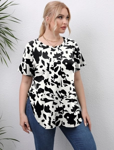Detail of plus size short sleeve top showing side slit hem and cow print pattern