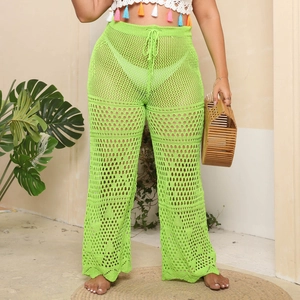 Detail of neon green crochet beach pants featuring hollow-out mesh texture and drawstring