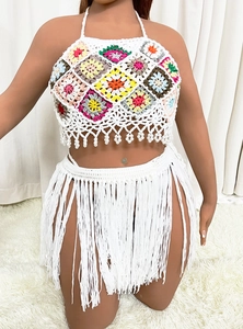 Detail of bohemian crochet set with colorful granny square top and long fringe skirt