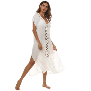Detail of white sheer beach dress with deep V-neck and intricate lace crochet embroidery
