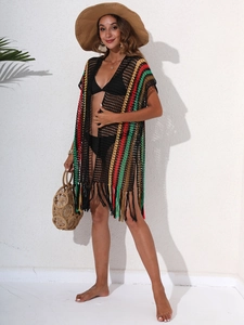 Detail of colorful striped crochet beach cover-up with fringe hem and boho knit texture