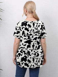 Back view of a women's plus size t-shirt featuring black and white abstract cow print