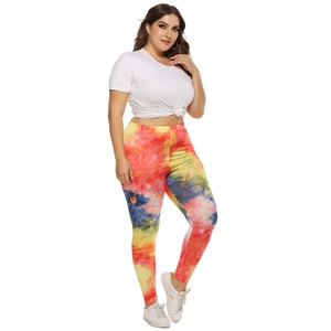 Close-up of women's plus size leggings featuring vibrant red, yellow and blue tie-dye pattern