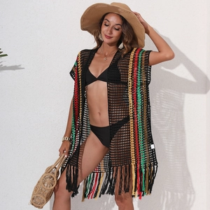 Detail of crochet beach cover-up with black mesh, colorful stripes, and fringe hem