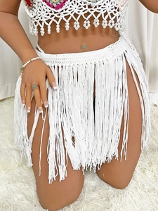 Detail showing white handmade crochet texture and long fringe tassels on bohemian beach skirt