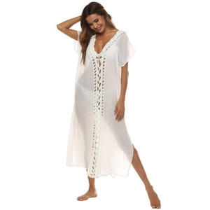 Detail of white deep V-neck beach cover-up featuring intricate crochet lace and side slits