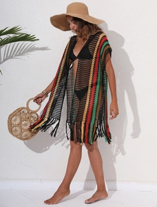 Detail of bohemian beach cover-up with colorful stripes and black fringe hemline