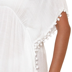 Robe de plage blanche à col en V avec bordure pompon et tissu à texture légère