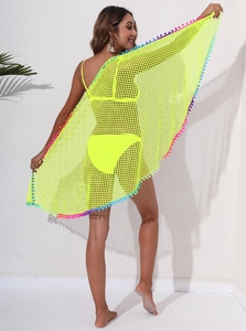 Détail du cache-maillot en résille jaune fluo avec pompons colorés vibrants sur l'ourlet