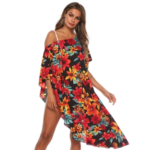 Détail de l'imprimé floral tropical sur un haut de plage noir avec ourlet asymétrique