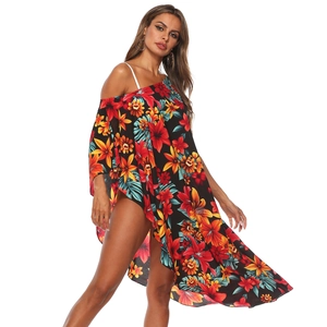 Détail d'un cache-maillot de plage à fleurs et ourlet asymétrique porté par un mannequin