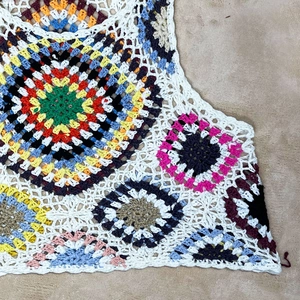 Detailed macro view of handmade boho crochet crop top with colorful mandala patterns